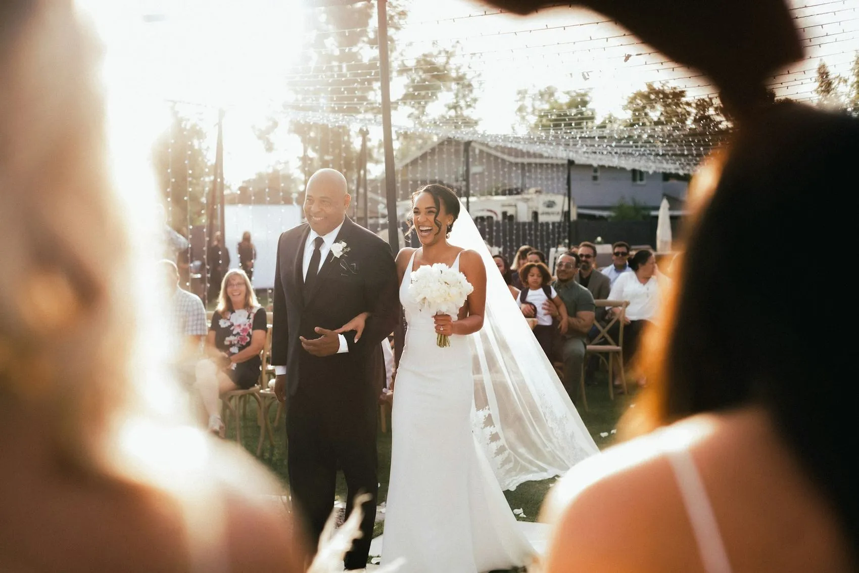 A bride walking down the aisle backlit by afternoon sun