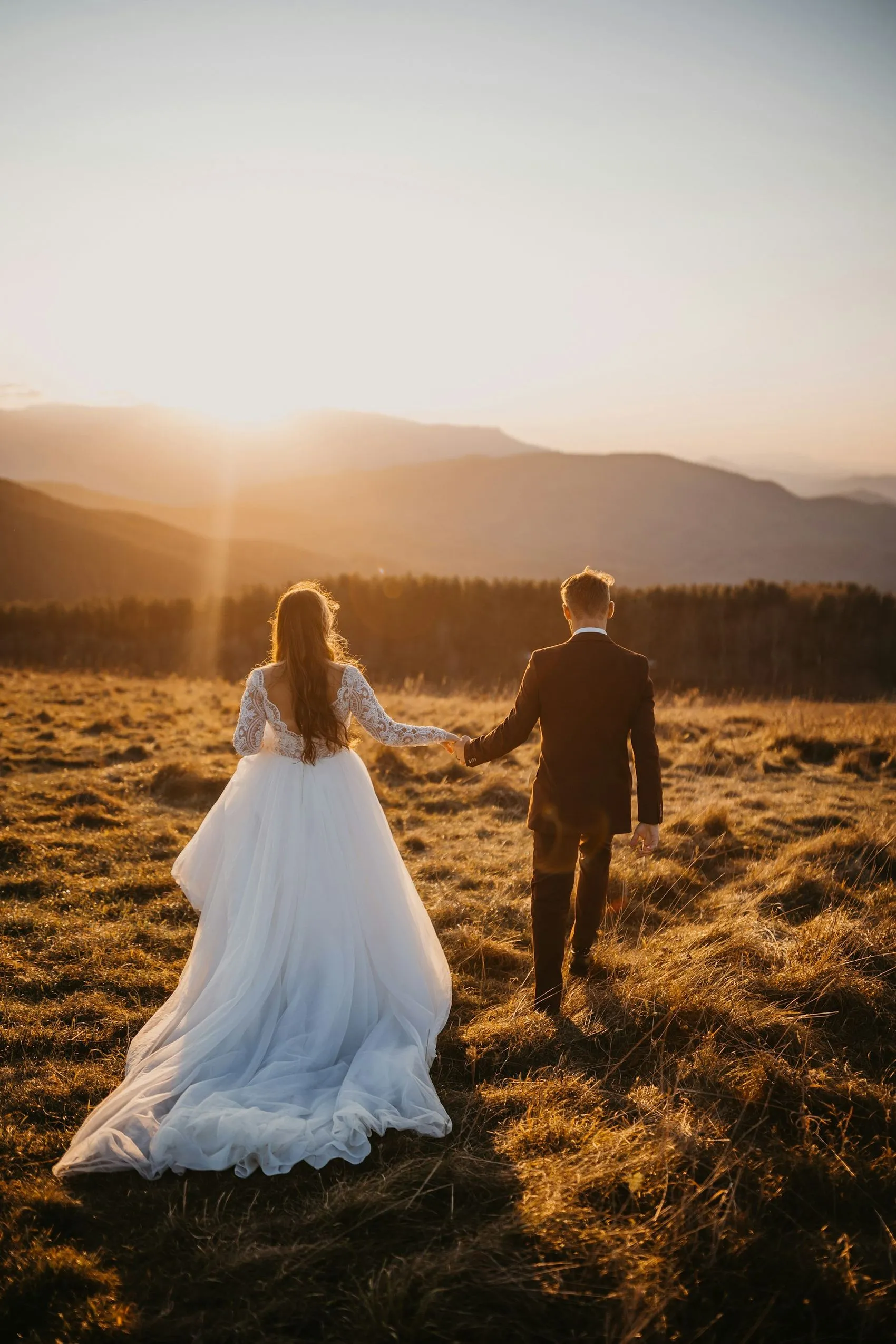 A couple running through a golden field at sunset in the Franschhoek valley
