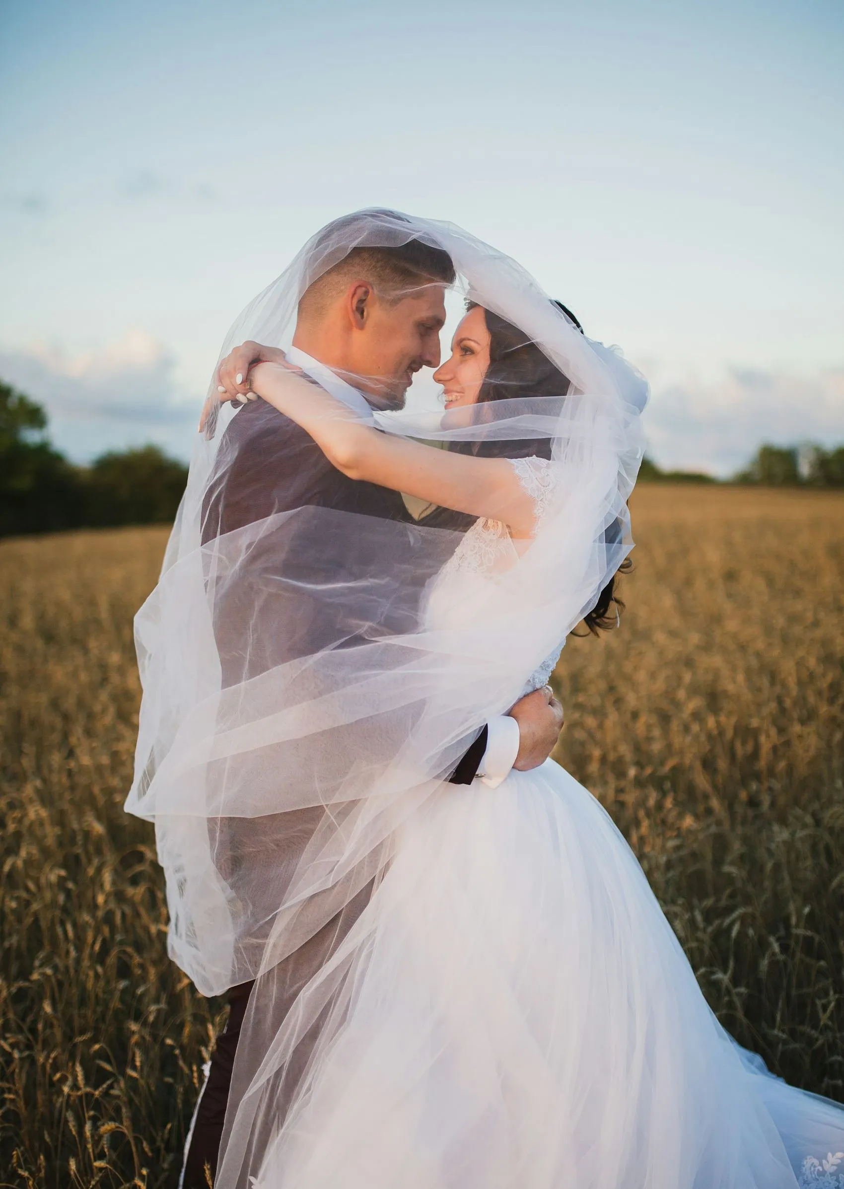 A veil caught in the wind around a couple