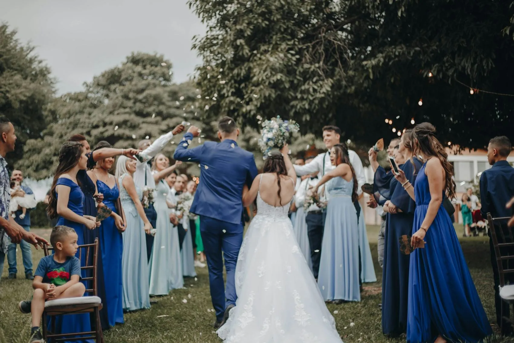 Guests celebrating around a couple outdoors