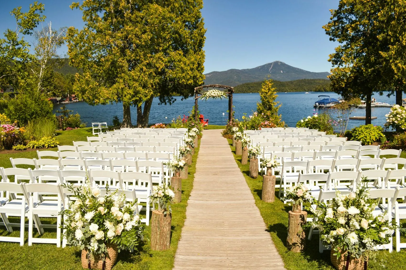 Rows of white chairs set for a ceremony beside water near Wellington