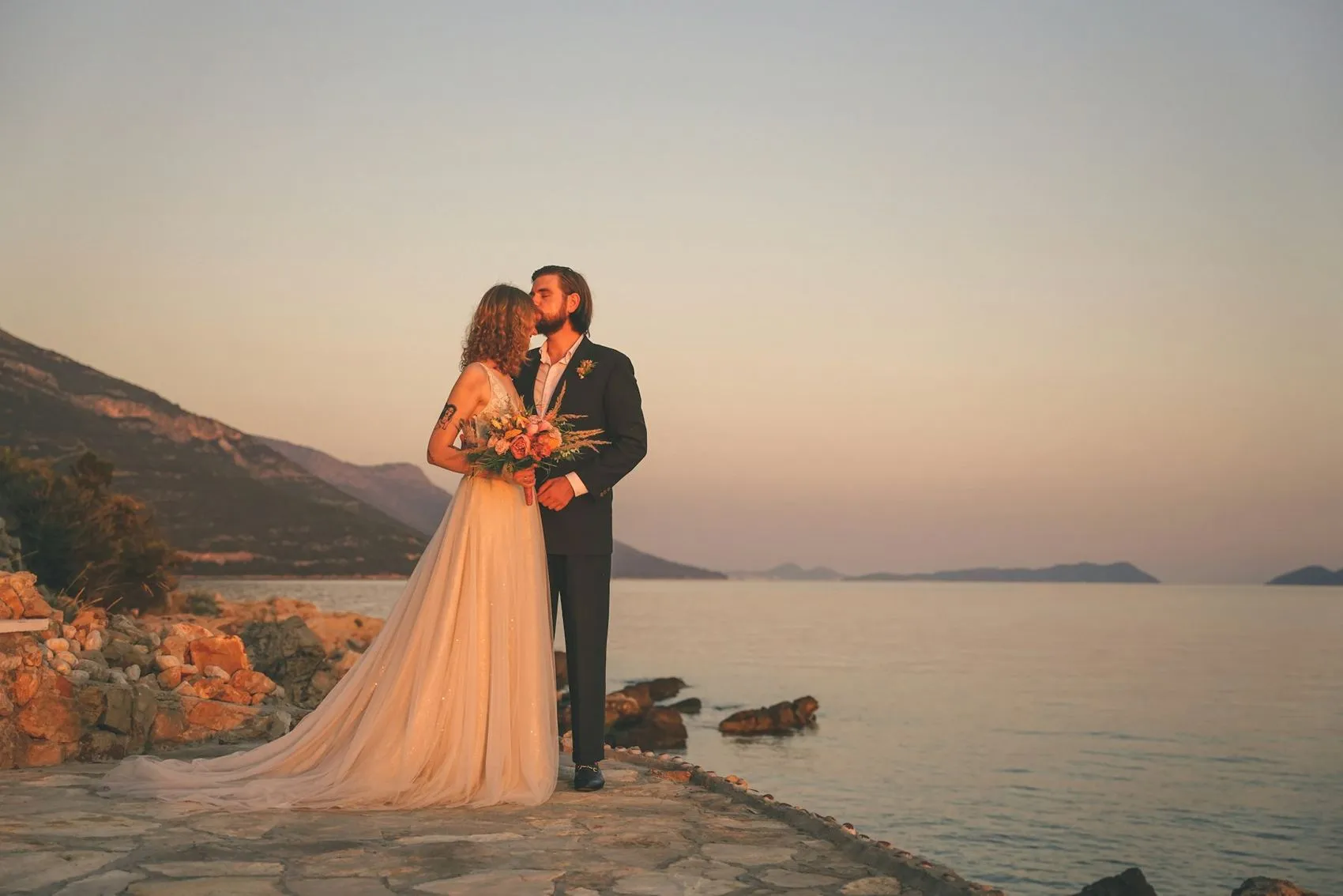 A couple photographed against the sea at sunset near Cape Town