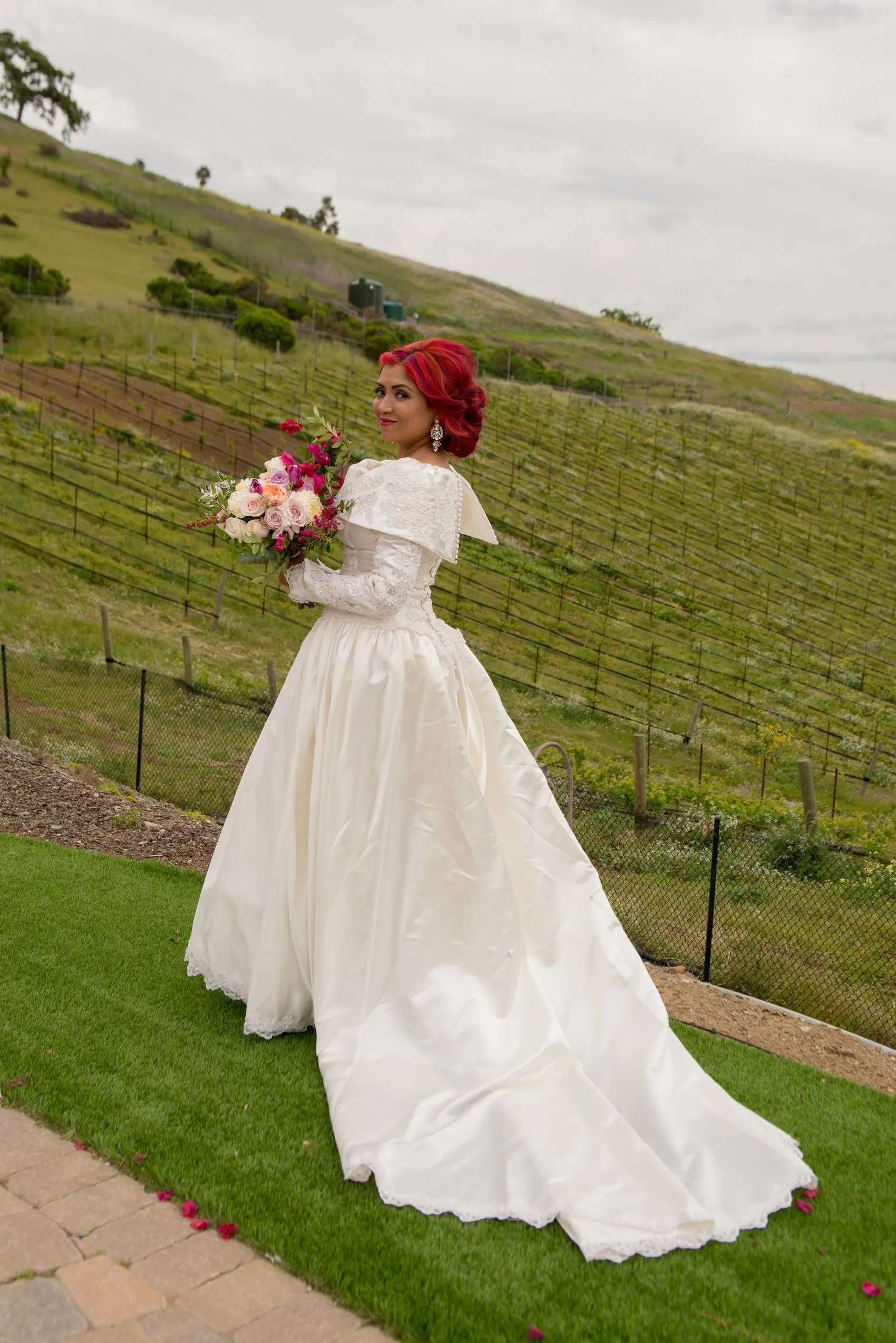 A bride in a long white dress standing in a Stellenbosch vineyard