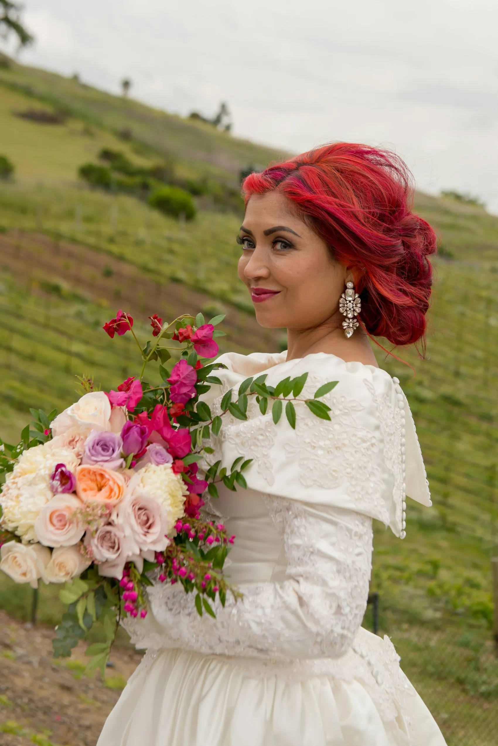 A bride walking through vineyard rows